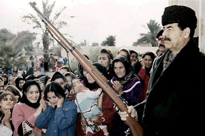 http://worldmeets.us/images/Saddam-Hussein-gun-hat_pic.png
